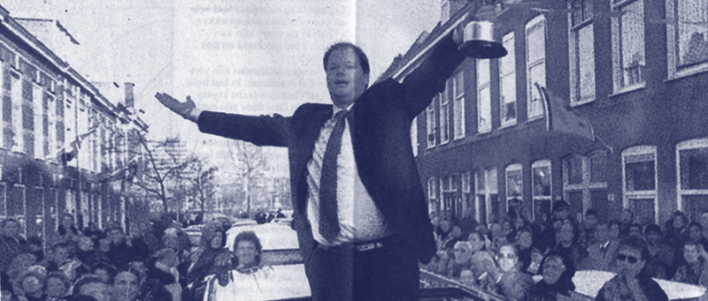 Raymond van Barneveld standing in a roofless car being paraded through the Dutch streets with the World Championship trophy.