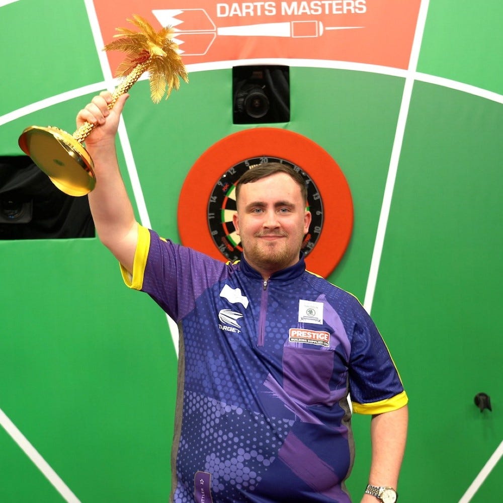 Luke Littler holding Bahrain Darts Masters Trophy from 2024