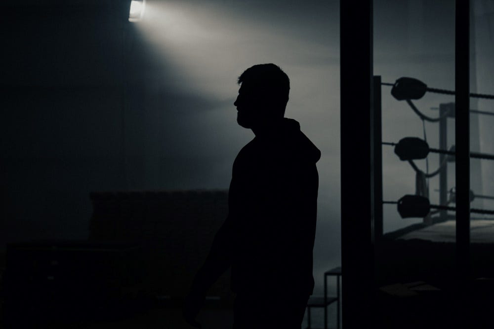 Sillouhette of Johnny Fisher next to boxing ring