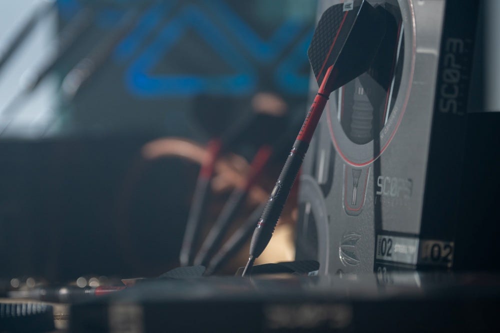 Scope darts in stylised shot next to their box